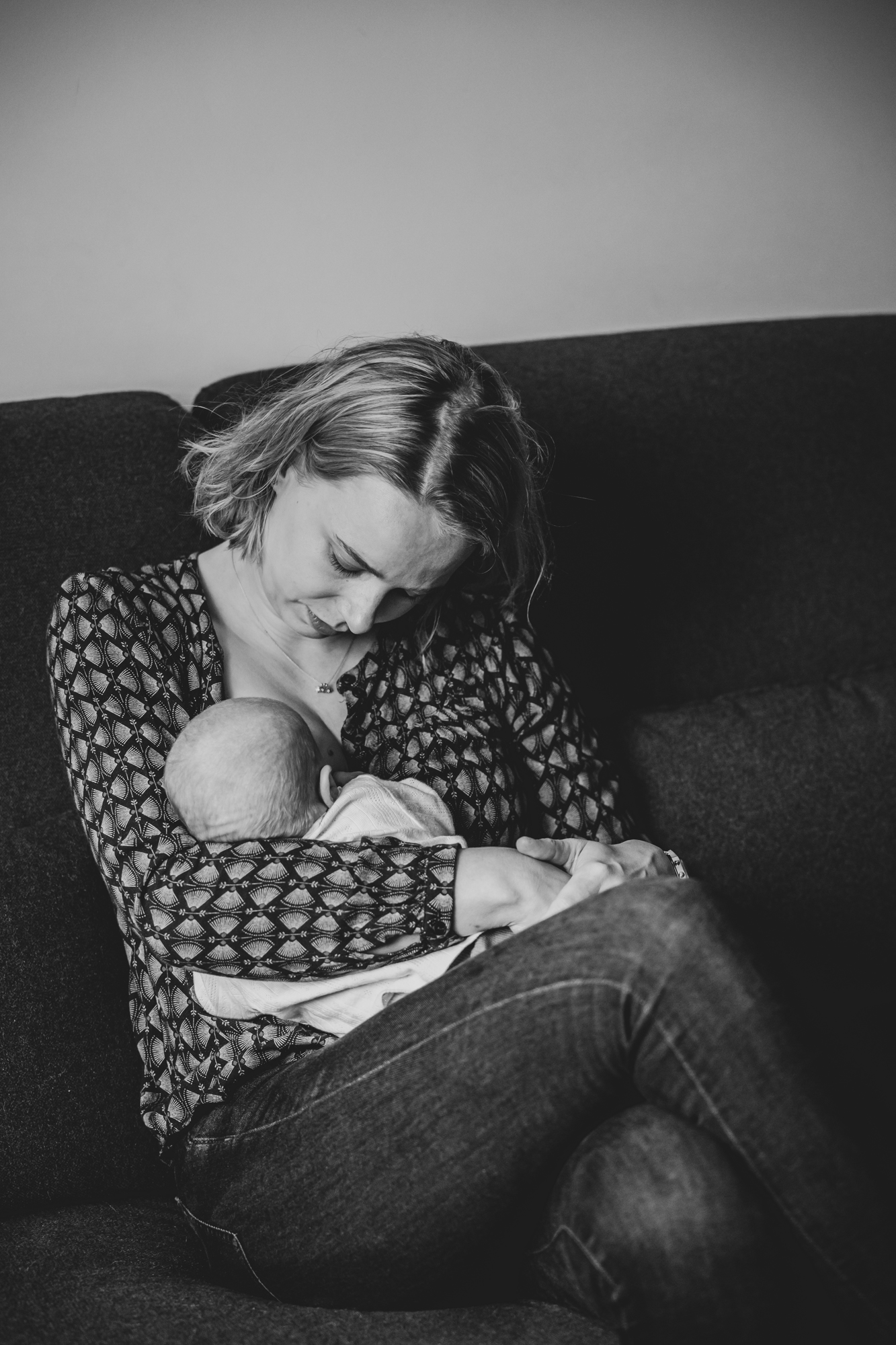 Newbornfotografie door fotograaf Nickie Fotografie uit Dokkum, Friesland. Moeder heeft haar pasgeboren kindje op schoot.