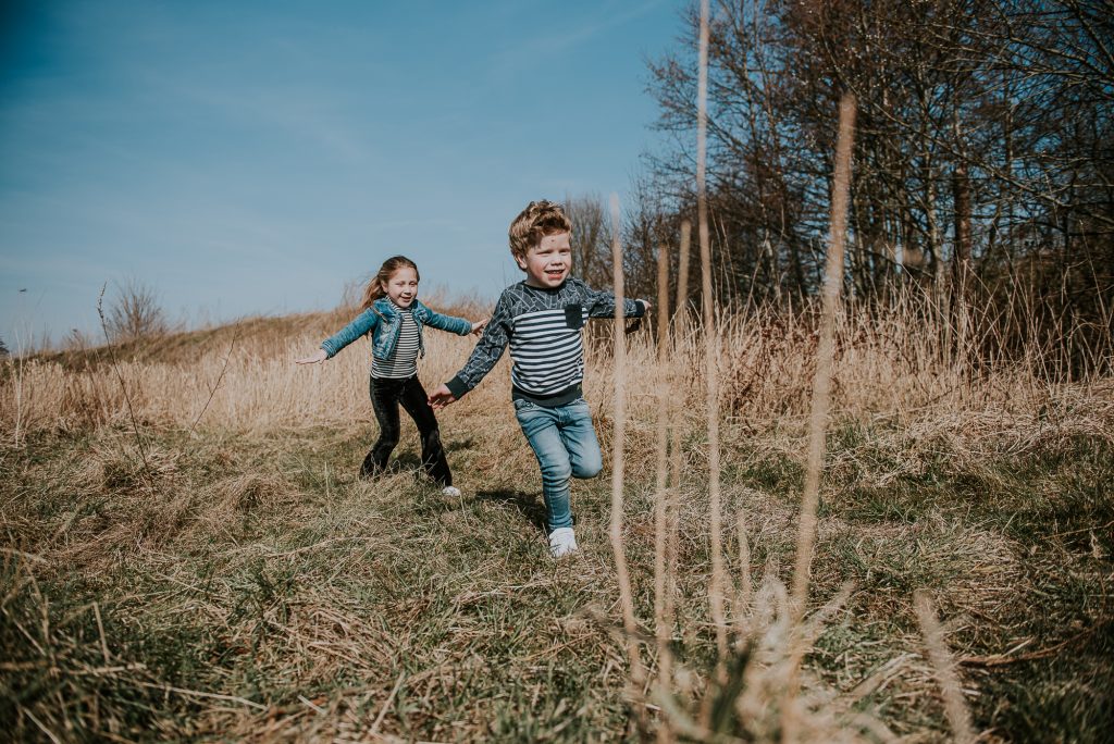 Fotograaf Groningen. Lifestyle gezinshoo. Spelende kinderen rennen door het natuurgebiedl Fotoshoot door Nickie Fotografie.