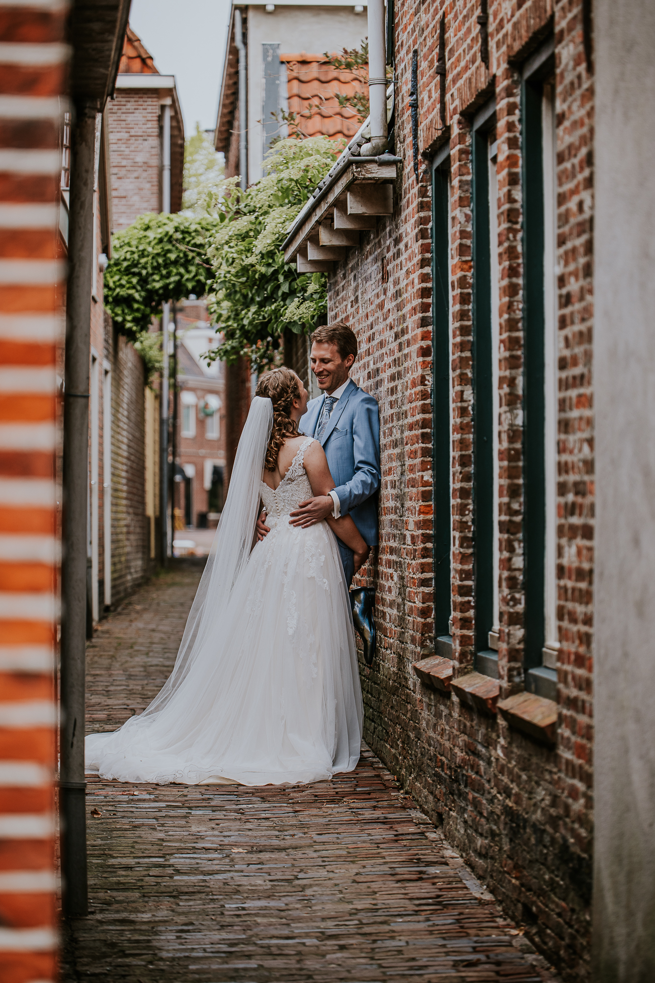 Bruidspaar in schattig steegje. Trouwfotografie door trouwfotograaf Nickie Fotografie uit Dokkum, Friesland.