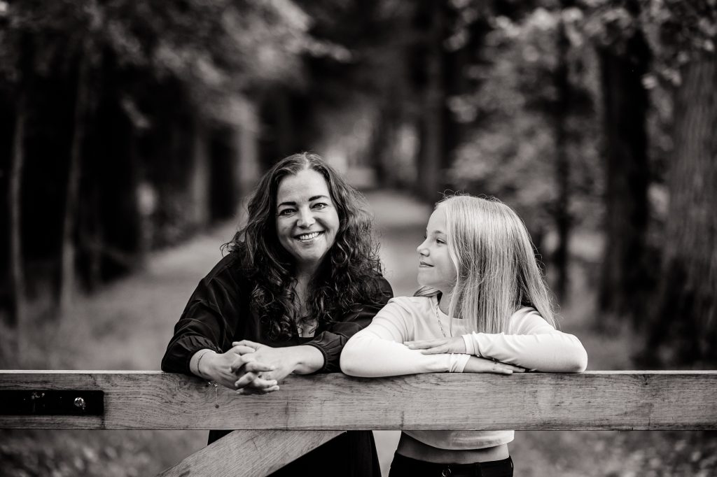 Fotoshoot Friesland van moeder met haar dochter bij een houten hek door fotograaf Nickie Fotografie uit Dokkum.