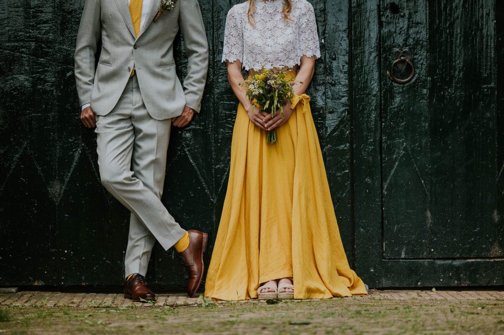 Trouwen in het geel. 
De bruid heeft een prachtige antiek gele rok aan met wit broderie top. De bruidegom draagt bijpassende gele accessoires. Huwelijksreportage door trouwfotograaf Nickie Fotografie.
