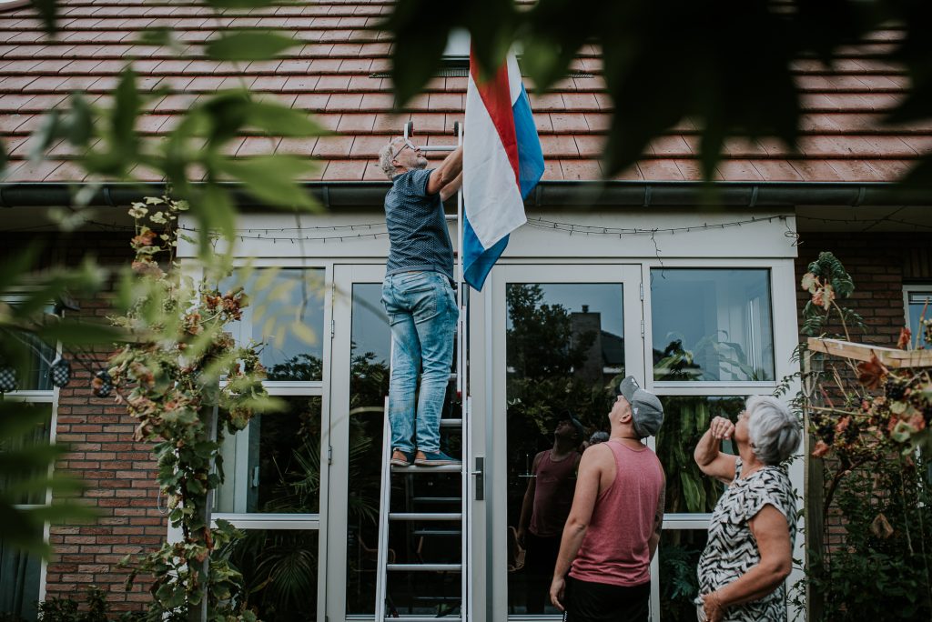 De vlag wordt opgehangen voor het bruidspaar. Bruidsreportage door Nickie Fotografie uit Dokkum, Friesland.