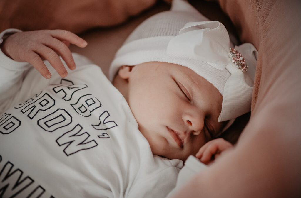 Babyfotografie Friesland, Leeuwarden, door fotograaf Nickie Fotografie. Baby ligt te slapen met een schattig mutsje met grote strik erop.