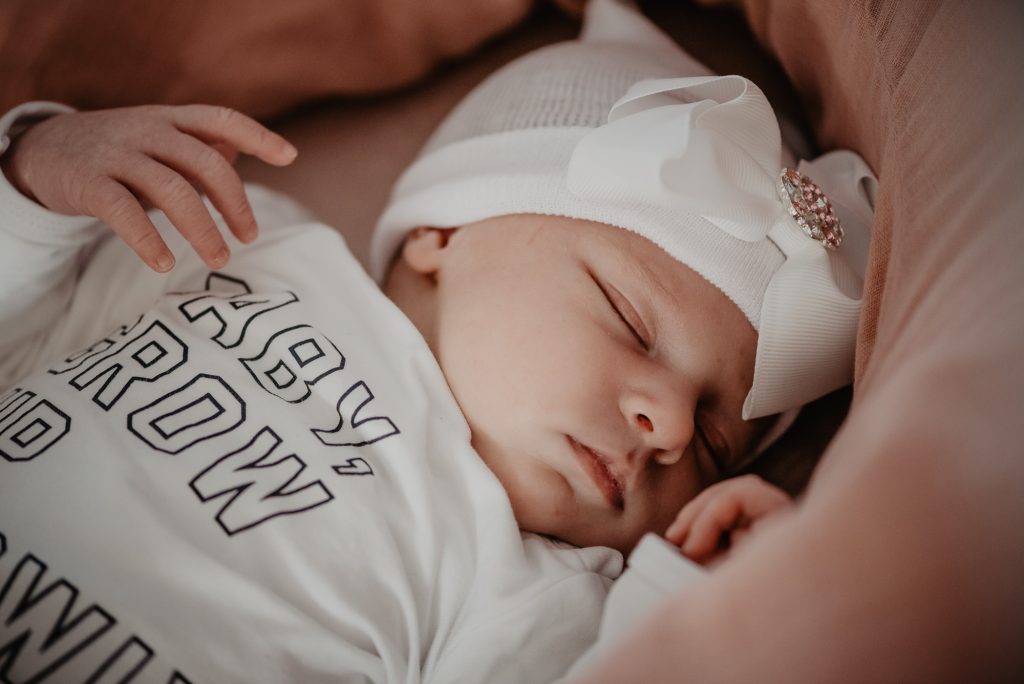 Babyfotografie Friesland, Leeuwarden, door fotograaf Nickie Fotografie. Baby ligt te slapen met een schattig mutsje met grote strik erop.