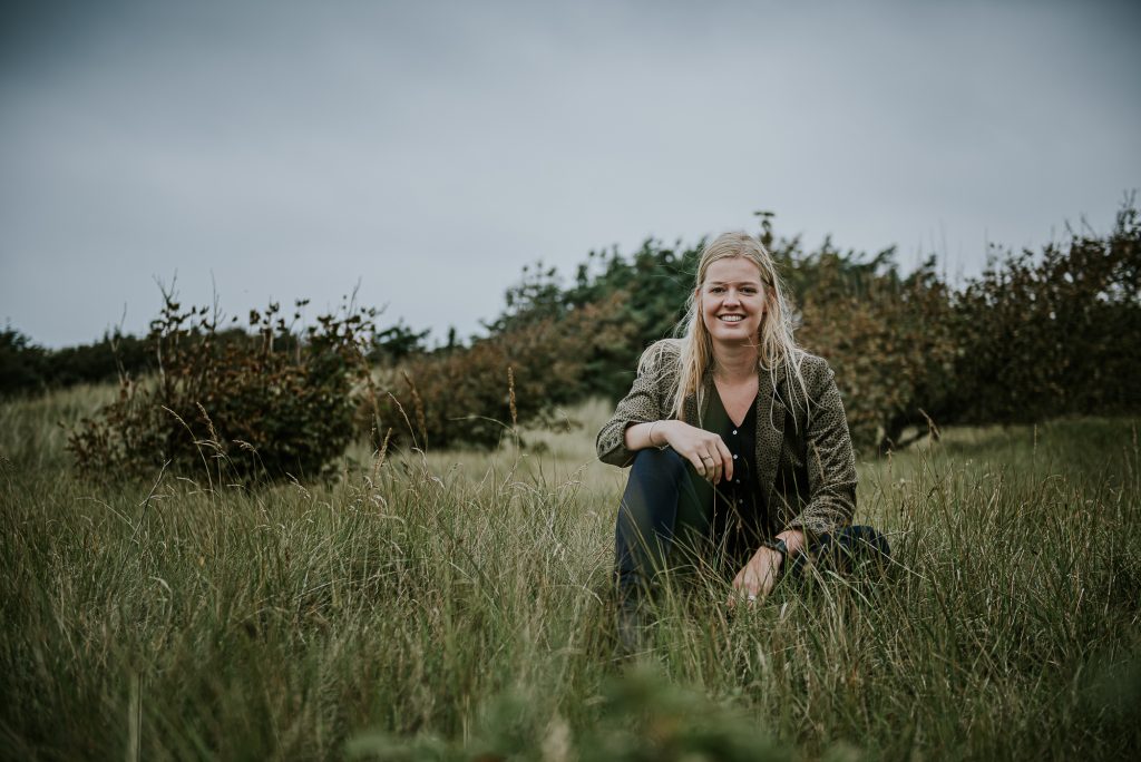 Portret zittend in het hoge gras door portretfotograaf Nickie Fotografie uit Dokkum
