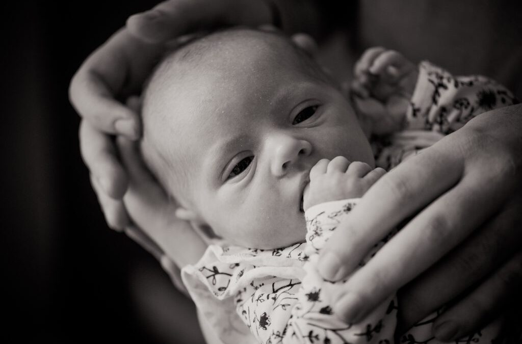 Newborn fotosessie Friesland, Leeuwarden, door newbornfotograaf Nickie Fotografie. Newbornmeisje wordt omringd door liefdevolle handen.