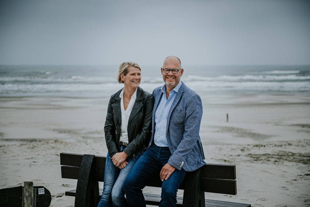 Portret van vader en moeder met op de achtergrond het strand van Ameland. Door portretfotograaf Nickie Fotografei uit Friesland
