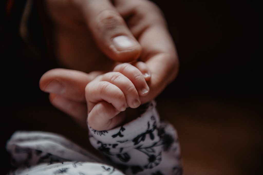 Fotoshoot baby. Babyhandje houdt vinger van haar moeder vast. Fotosessie door fotograaf NIckie Fotografie uit Dokkum.