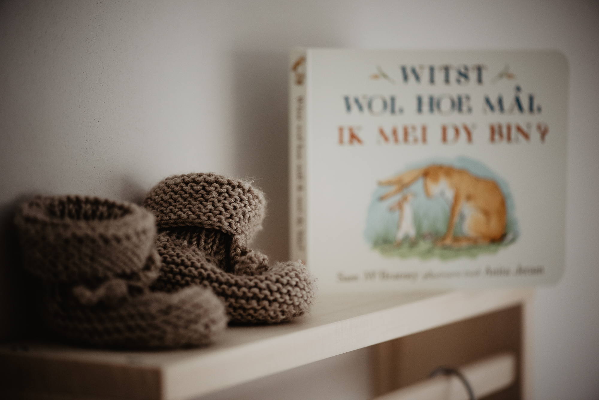 Gebreide babyslofjes bij Winnie de Poeh boekje. Fotoreportage door fotograaf Nickie Fotografie uit Dokkum, Friesland.