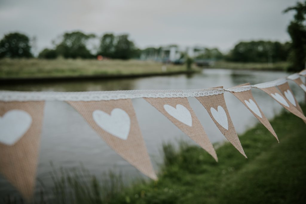 Bruiloft decoratie, jute harten trouwslinger. Huwelijksfotografie door huwelijksfotograaf Nickie Fotografie uit Dokkum, Friesland