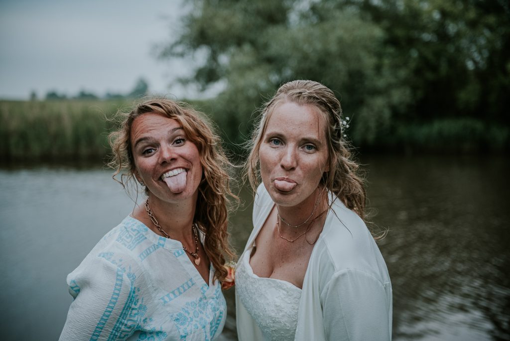 Geinige foto van de bruid en haar zus. Bruidsfotografie door bruidsfotograaf Nickie Fotografie uit Dokkum, Friesland