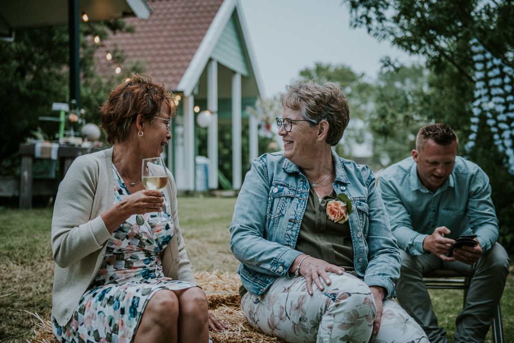 Gezellig met elkaar kletsen op de bruiloft. Bruidsfotografie door bruidsfotograaf Nickie Fotografie uit Dokkum, Friesland