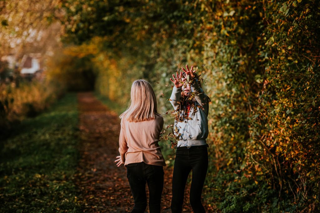 Tieners spelen met herfstbladeren. Fotoshoot Friesland door fotograaf Nickie Fotografie uit Dokkum