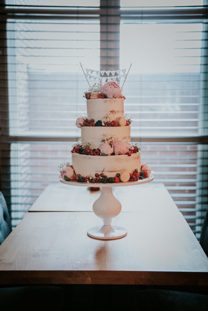 Bruidstaart, semi naked cake met fruit en bloemen. Trouwfotografie door trouwfotograaf Nickie Fotografie uit Dokkum, Friesland