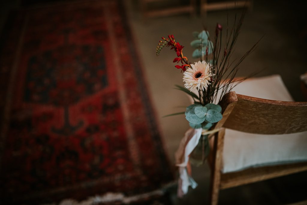 Bruiloft stoeldecoratie met bloemwerk. Trouwreportage door trouwfotograaf Nickie Fotografie uit Dokkum, Friesland