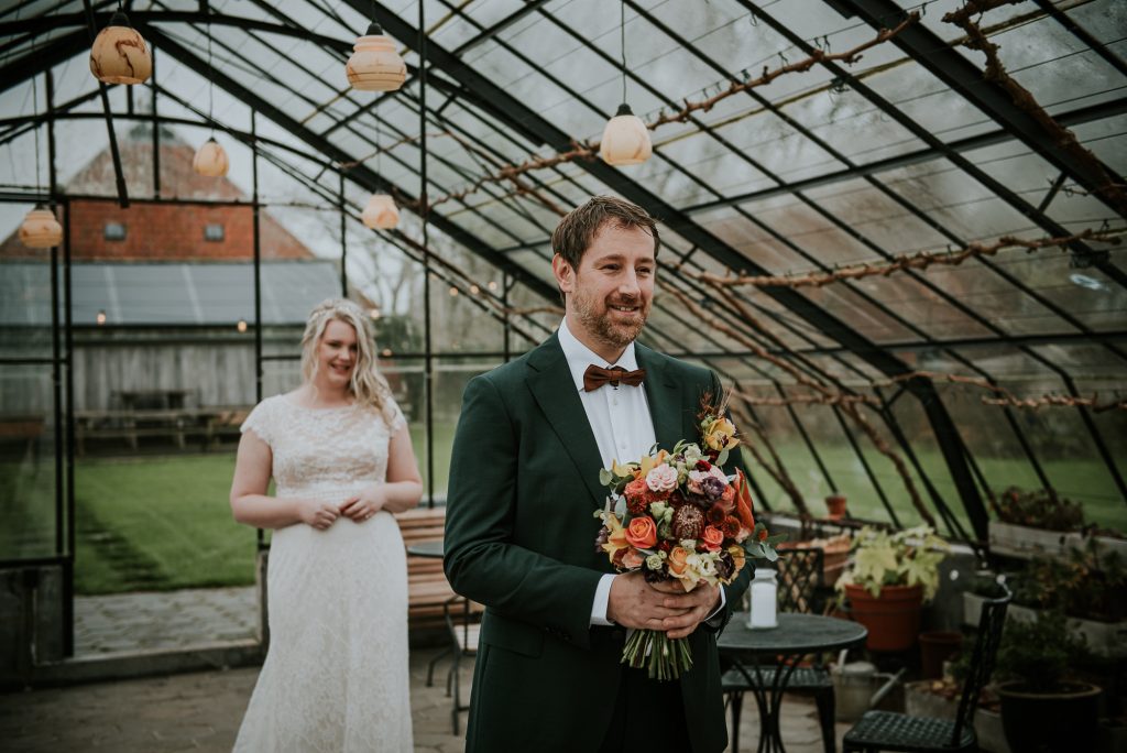Trouwfotograaf Friesland. 1e Blik tussen bruid en bruidegom in de kas van It Flinkeboskje. Huwelijksfotografie door huwelijksfotograaf Nickie Fotografie uit Dokkum