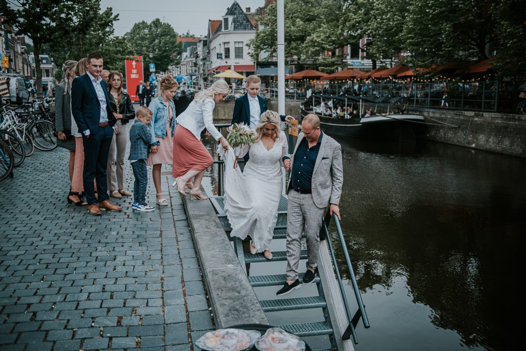 Bruidspaar onderweg naar het huwelijksbootje, rondvaart door Leeuwarden. Huwelijksreportage door huwelijksfotograaf Nickie Fotografie uit Dokkum, Friesland