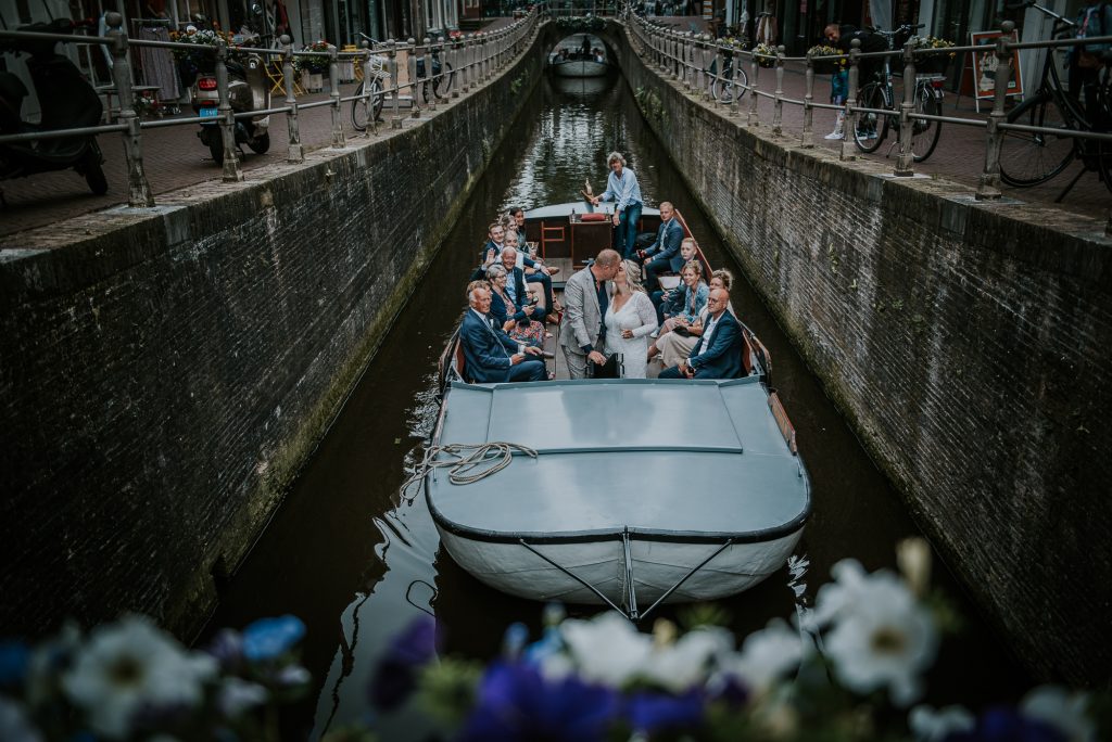 Bruidspaar is in het huwelijksbootje gestapt. Rondvaart door het centrum van Leeuwarden. Bruidsreportage door bruidsfotograaf Nickie Fotografie uit Dokkum, Friesland