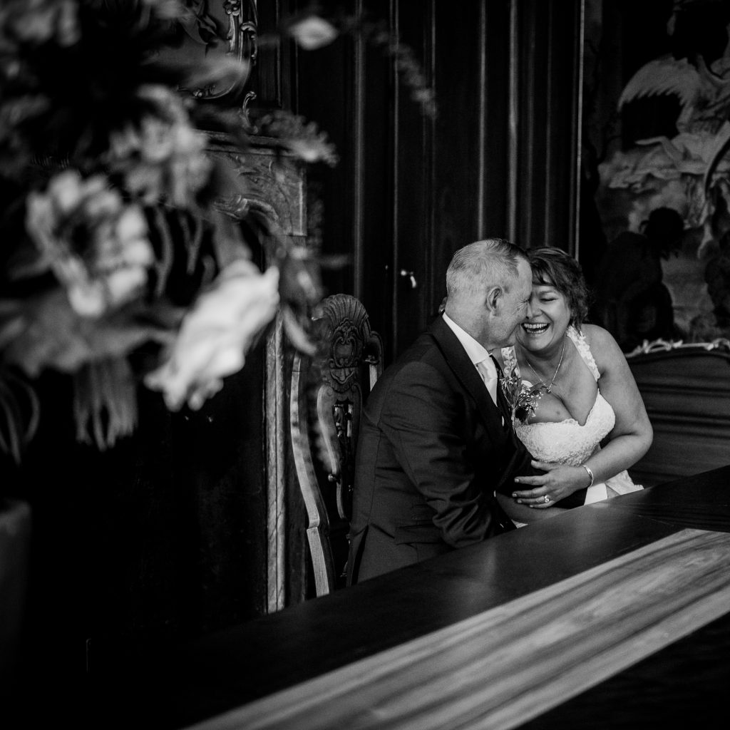 Het bruidspaar heeft een lief momentje tijdens de trouwceremonie. Huwelijksfotografie door trouwfotograaf Nickie Fotografie uit Friesland.