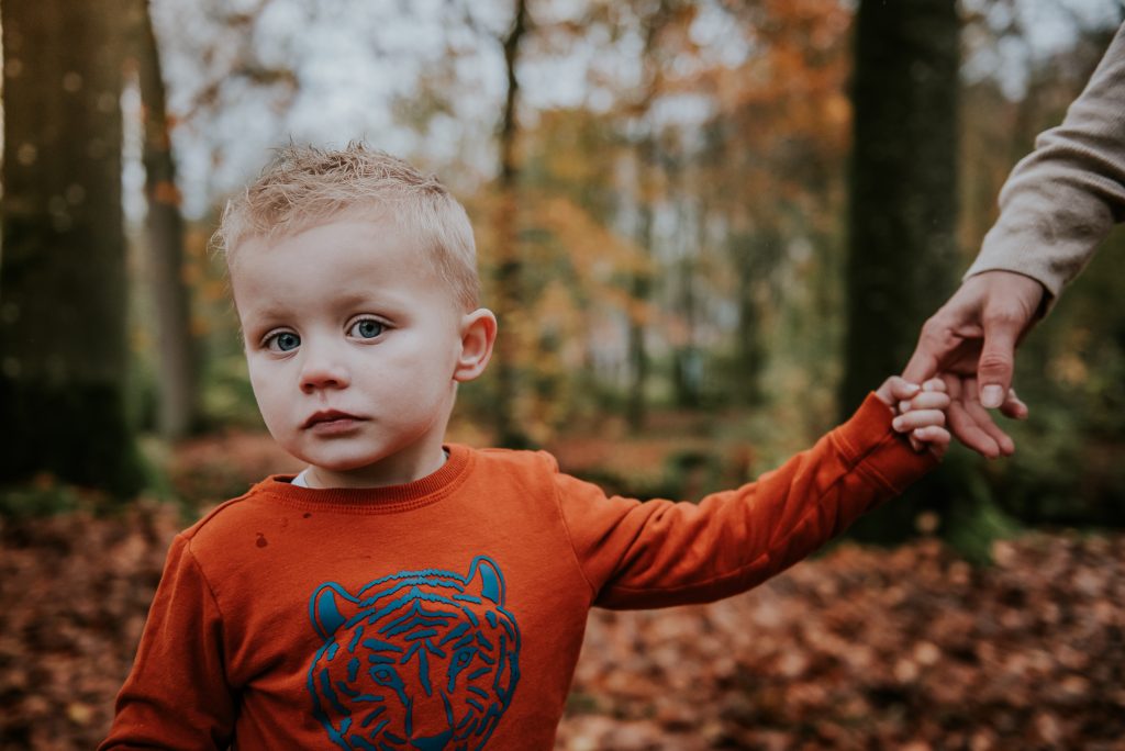 Portret van verlegen jongetje in het bos door fotograaf NIckie Fotografie uit Dokkum, Friesland.