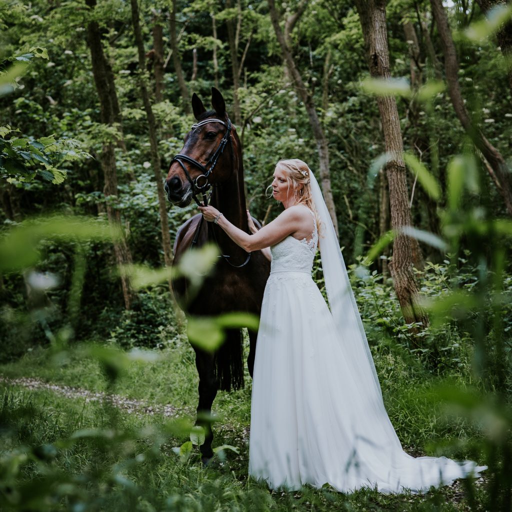 Bruid met haar paard. huwelijksshoot door huwelijksfotograaf Nickie Fotografie uit Dokkum, Friesland.