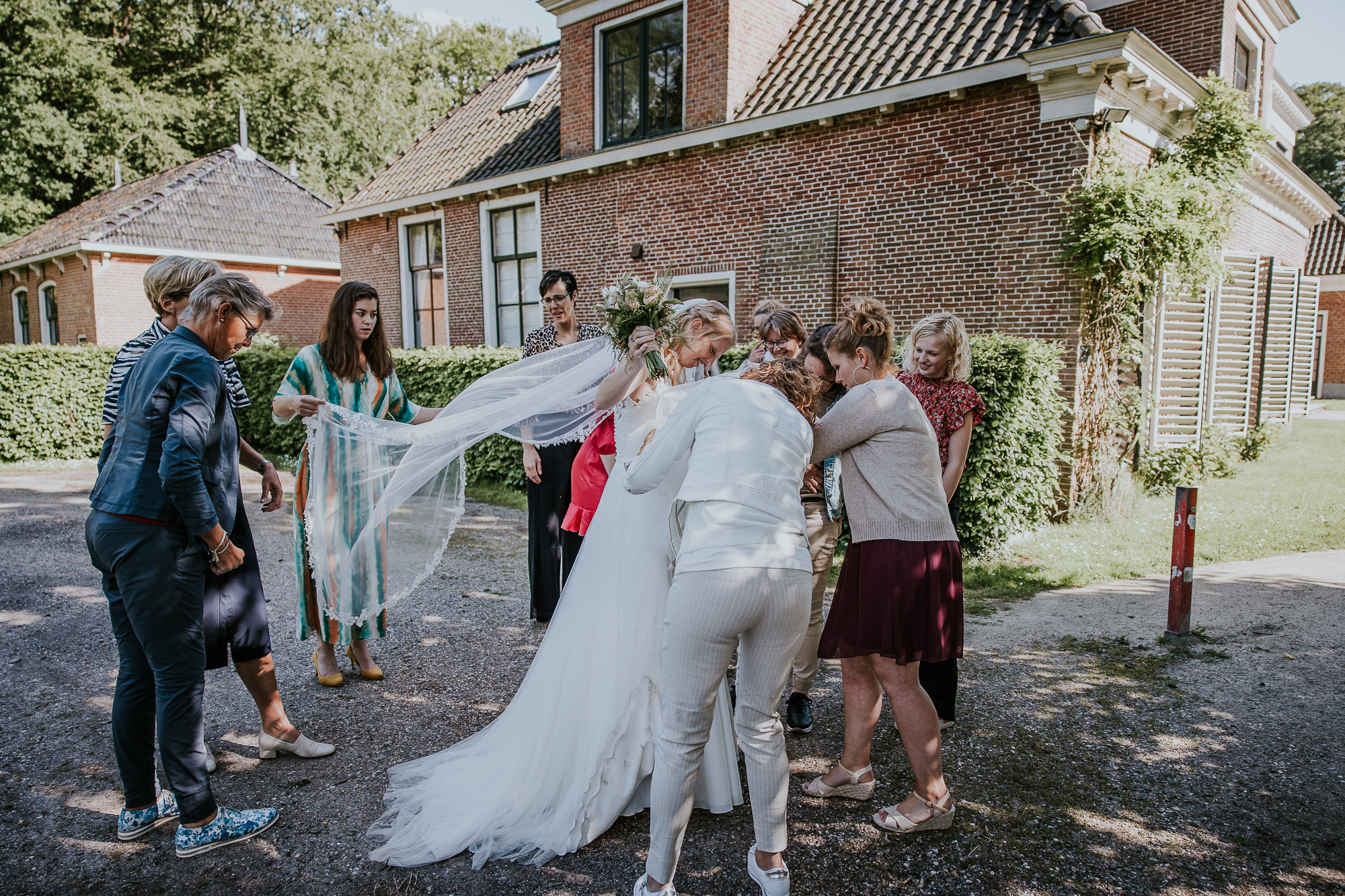 Vriendinnen bewonderen de bruidsjurk,  van  Bruid & Bubbels. Bruidsfotografie door bruidsfotograaf Nickie Fotografie uit Friesland.