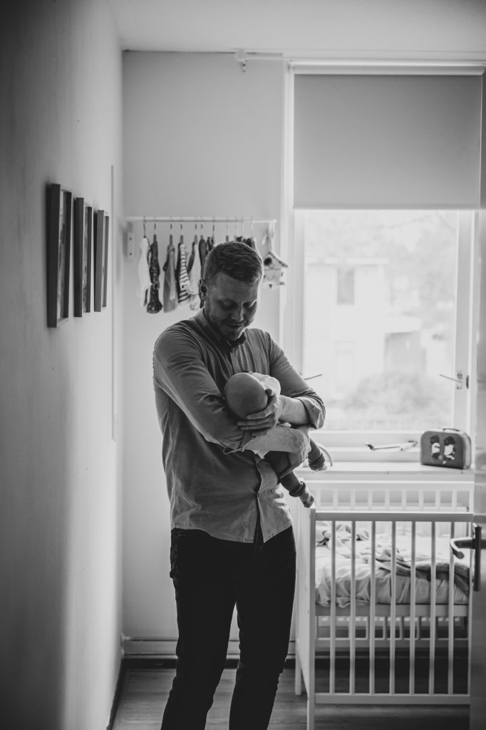 Newbornshoot Assen door babyfotograaf Nickie Fotografie. Vader met pasgeboren dochtertje.
