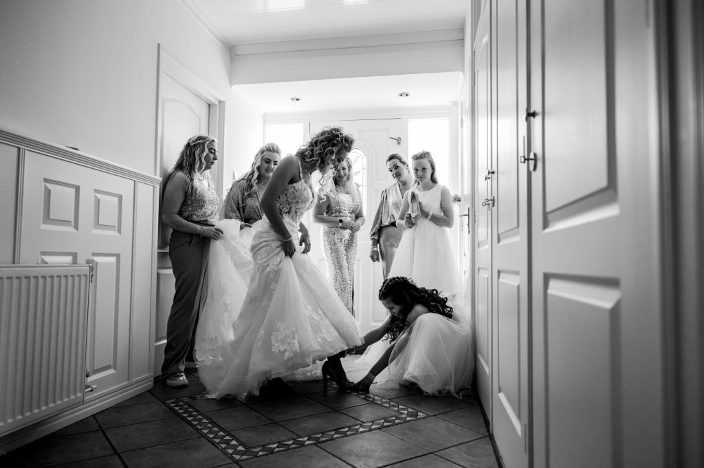 Trouwfotograaf Friesland, Nickie Fotografie. Dochter helpt bij het aankleden van de bruid.