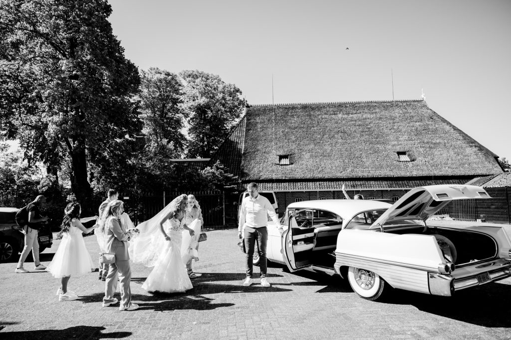 Een oude witte Cadillac als trouwauto. Huwelijksfotografie door huwelijksfotograaf Nickie Fotografie.