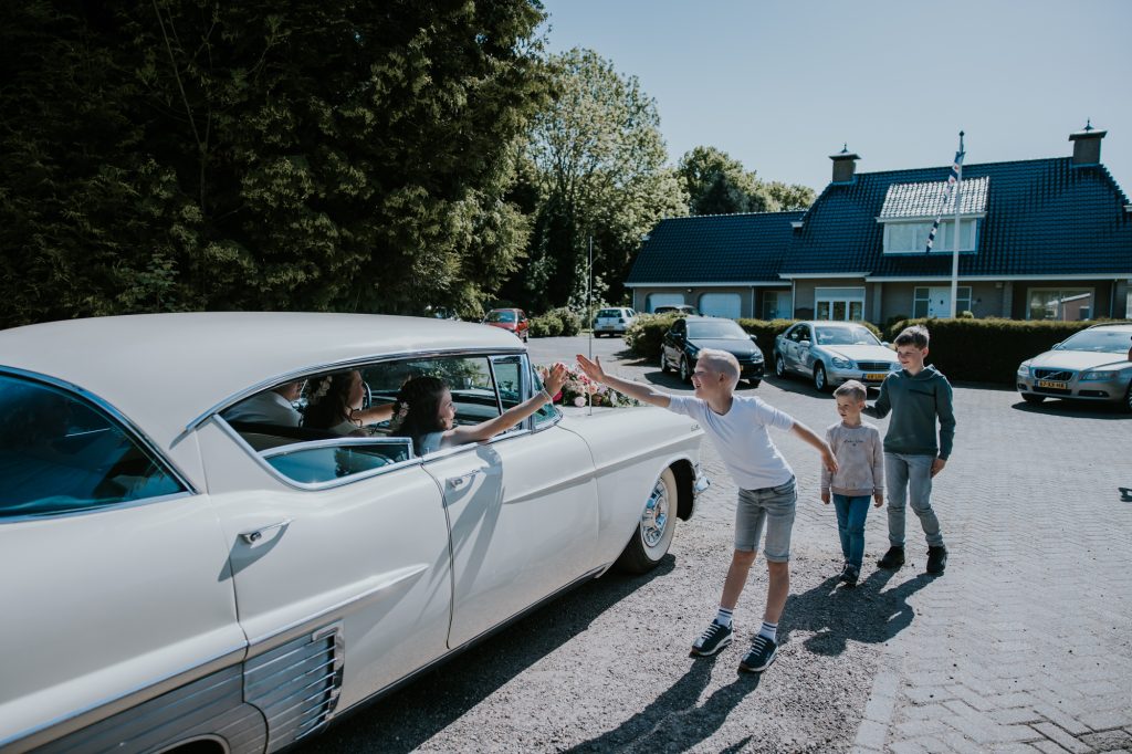 Prachtige oude witte Cadillac als trouwauto bij de trouwerij in Twijzel, Friesland. Trouwreportage door trouwfotograaf NIckie Fotografie.