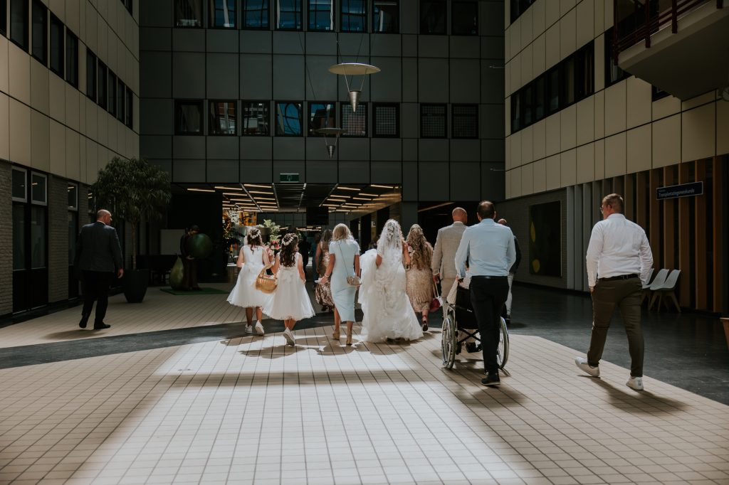 Trouwen in het ziekenhuis, UMCG. De trouwstoet loopt door het ziekenhuis. Bruidsreportage door bruidsfotograaf Nickie Fotografie.