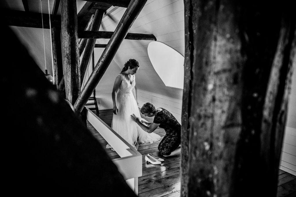 Trouwen in Friesland, Aalsum. Zwartwit trouwreportage door trouwfotograaf Nickie Fotografie. Het aankleden van de bruid in oude boerderij.