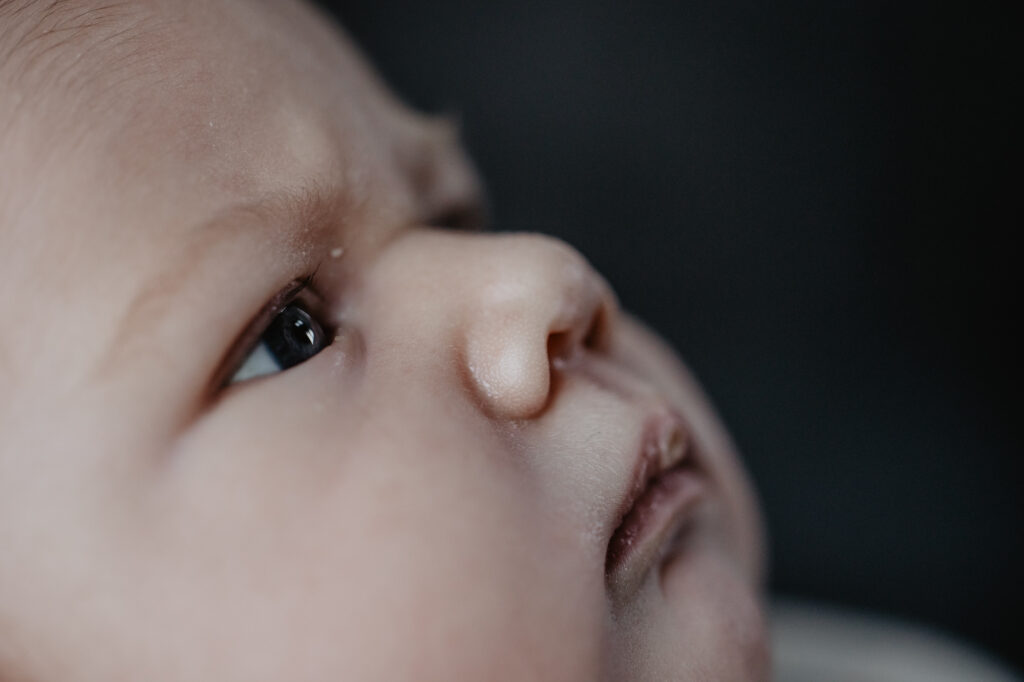 Close-up babyportret. Newborn heeft serieuze blik. Fotoshoot door babyfotograaf Nickie Fotografie uit Dokkum, Friesland.