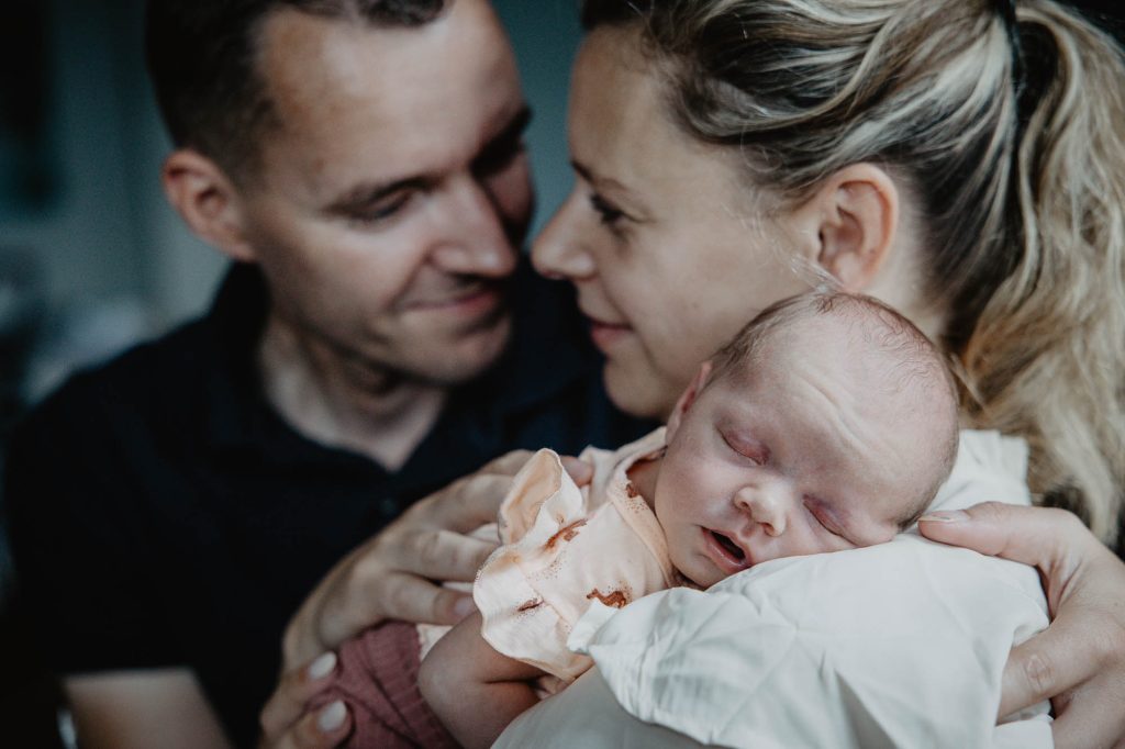 Newbornshoot Burgum door fotograaf Nickie Fotografie uit Friesland. Vader en moeder met pasgeboren dochtertje.