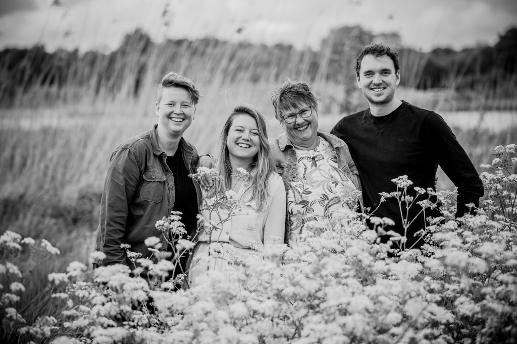 Portret van moeder met haar drie al volwassen kinderen achter het fluitenkruid door portretfotograaf Nickie Fotografie uit Dokkum, Friesland.