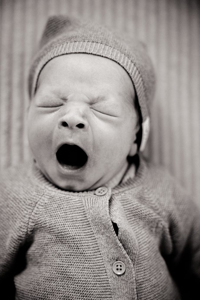 Zwart-wit foto van gapende baby. Babyshoot door babyfotograaf Nickie Fotografie uit Dokkum.