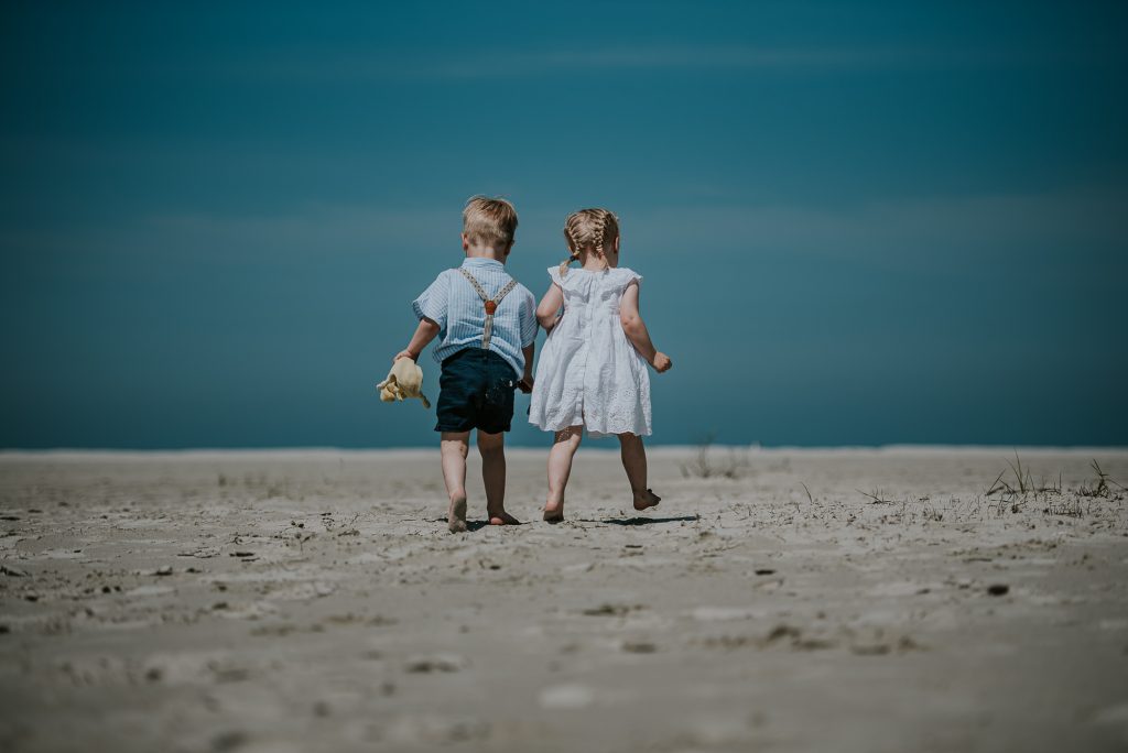 Tweeling trekt samen de weide wereld in. Kinderfotografie op Schiermonnikoog door fotograaf Nickie Fotografie uit Dokkum, Friesland