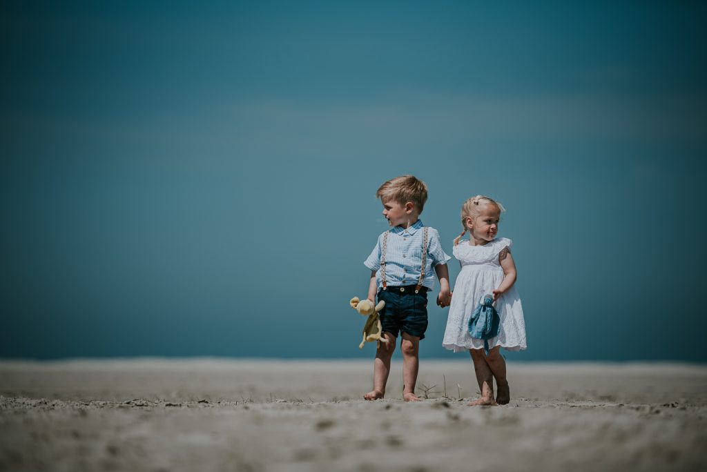 Tweelingportret op het witte strand van Schiermonnikoog door fotograaf Nickie Fotografie uit Dokkum, Friesland