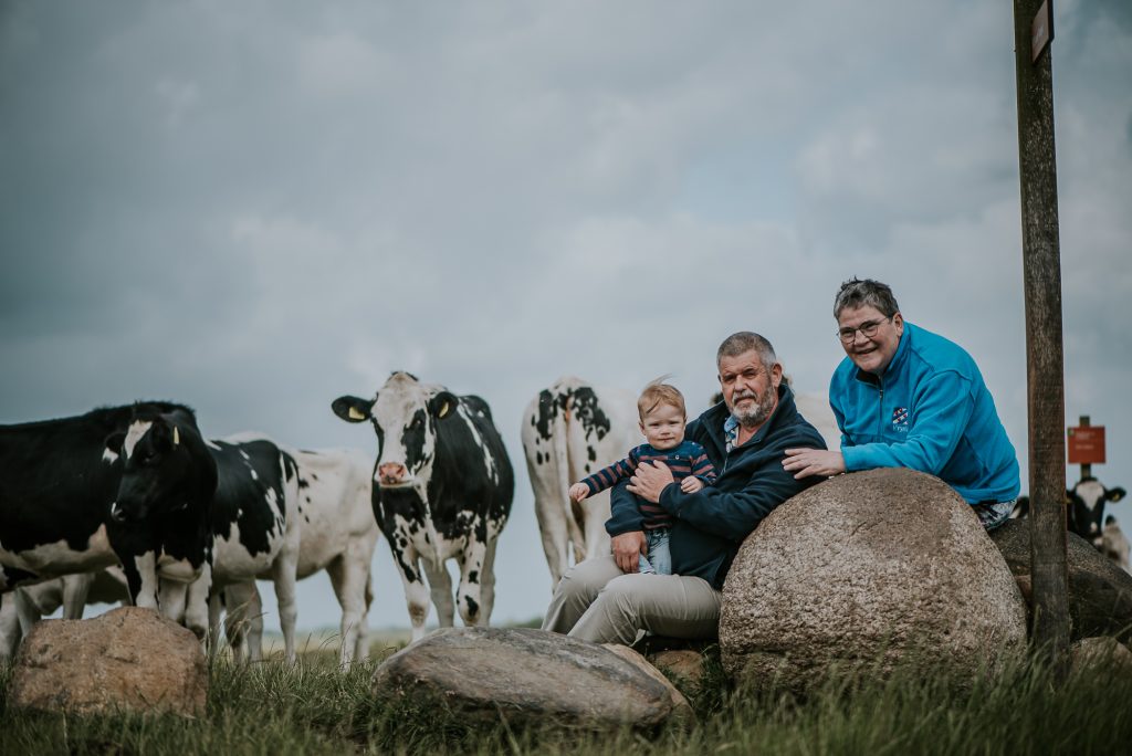 Portret van opa en oma met kleinzoon tusssen de koeien door portretfotograaf Nickie Fotografie uit Dokkum, Friesland