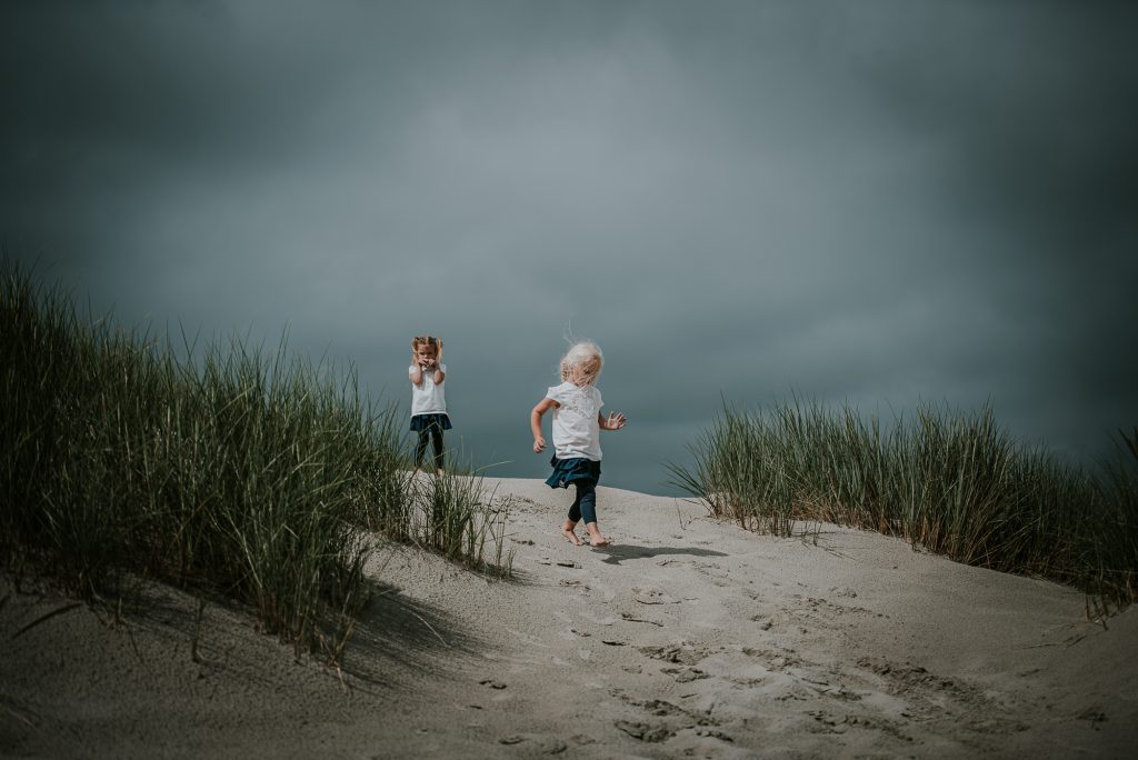 Fotosessie van twee zussen in de duinen van het Waddeneiland door kinderfotograaf Nickie Fotografie uit Dokkum, Friesland