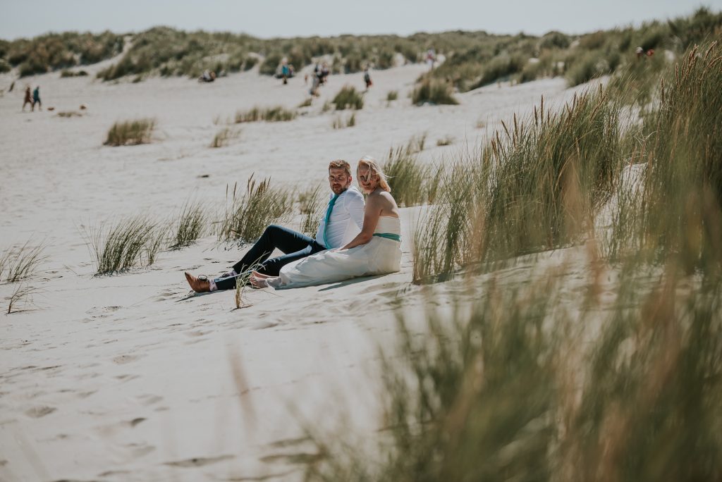 Vijf jarig trouwjubileum vieren door een fotoshoot in trouwkleding op het strand. Fotosessie door fotograaf Nickie Fotografie uit Dokkum, Friesland.