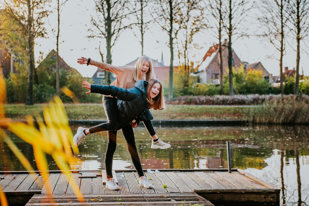 Twee tieners lekker gek aan het doen in het gouden uur. Tienershoot door fotograaf Nickie Fotografie uit Dokkum, Friesland