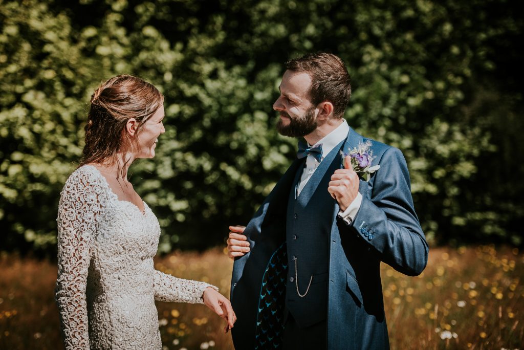 Bruidegom laat binnenkant van zijn trouwjasje zien. Trouwreportage door trouwfotograaf Nickie Fotografie uit Dokkum, Friesland