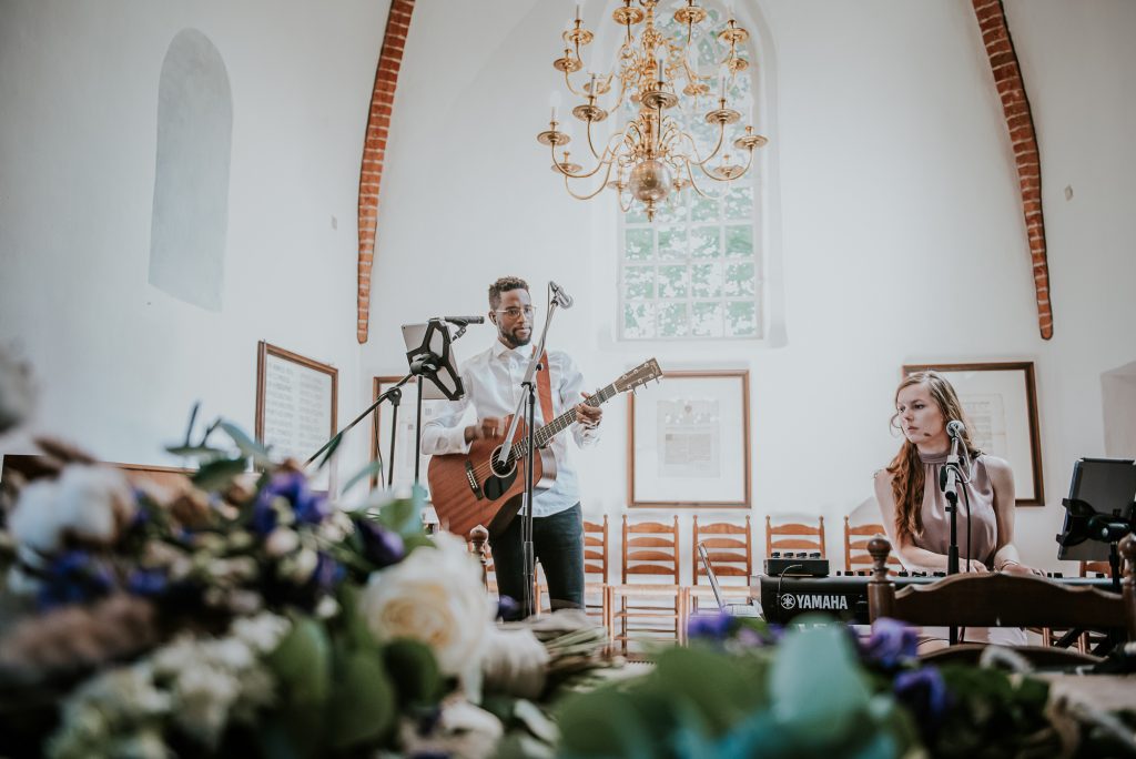 De band speelt en zingt tijdens de kerkelijke inzegening. Huwelijksfotografie door huwelijksfotograaf Nickie Fotografie uit Dokkum, Friesland.