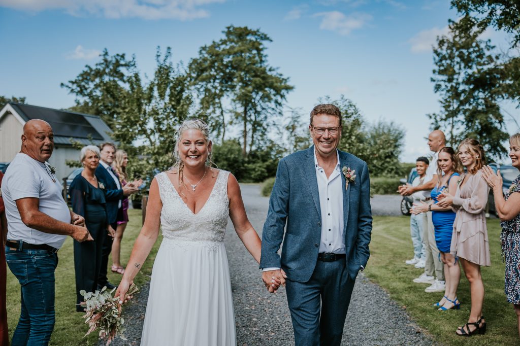 Het bruidspaar wordt ontvangen bij Schreiershoek door een erehaag. Bruidsfotografie door trouwfotograaf Nickie Fotografie uit Dokkum, Friesland.