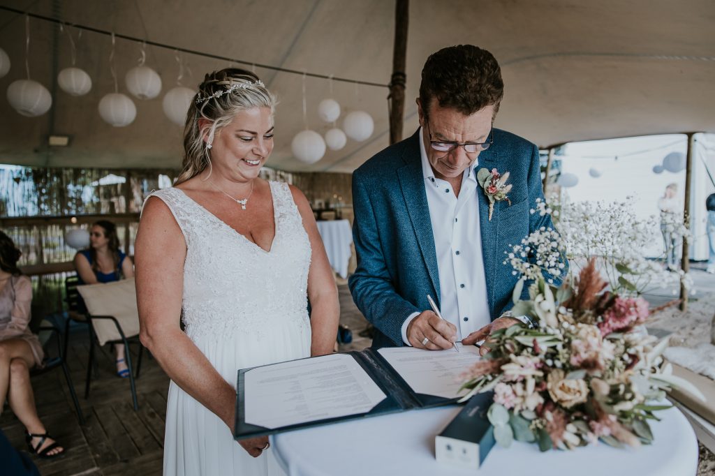 Het zetten van de handtekening op de trouwakte. Bruidsreportage door huwelijksfotograaf Nickie Fotografie uit Dokkum, Friesland.