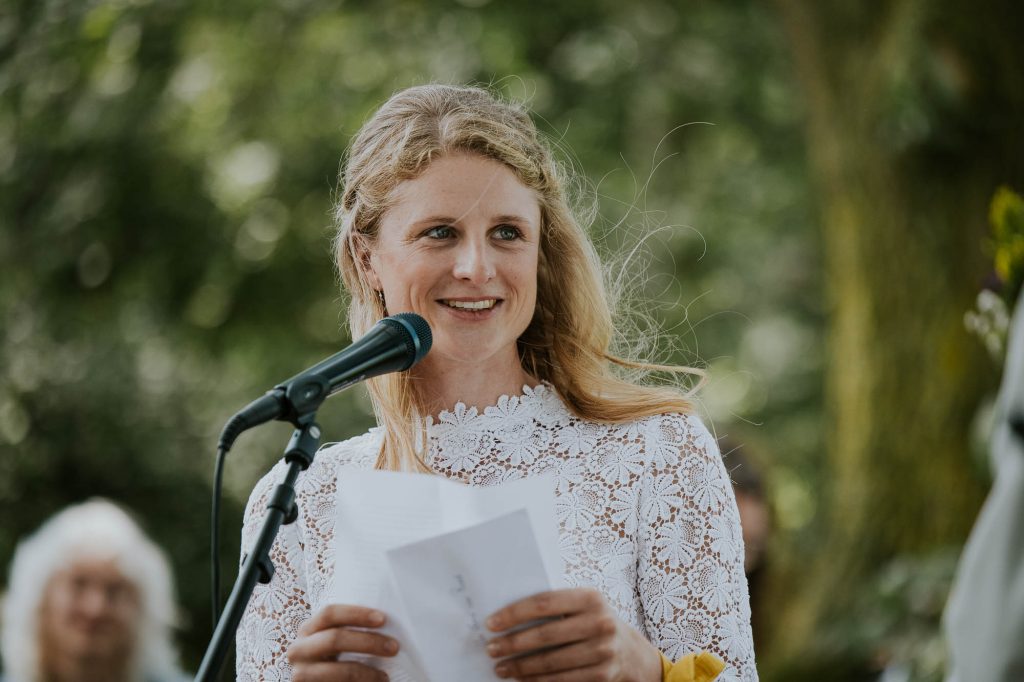 Bruid leest haar eigen geschreven huwelijksgelofte voor tijdens de buiten bruiloft. Trouwfotografie door trouwfotograaf NIckie Fotografie uit Dokkum, Friesland.