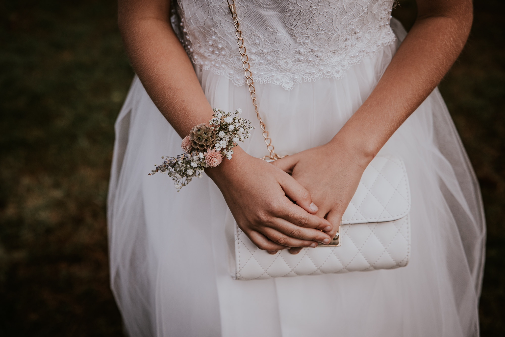 Trouwfotograaf Friesland, Nickie Fotografie. Detailshot van het bruidsmeisje met handtasje en armband bloemencorsage.