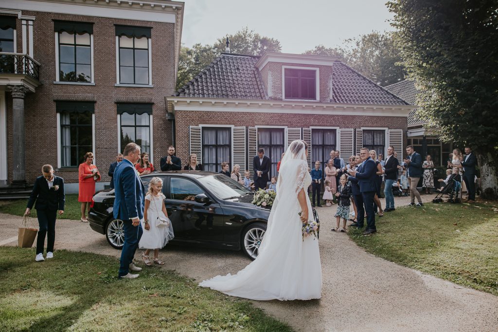Bruid en bruidegom worden ontvangen door de daggasten op hun trouwlocatie. Trouwreportage door trouwfotograaf Nickie Fotografie uit Dokkum, Friesland.