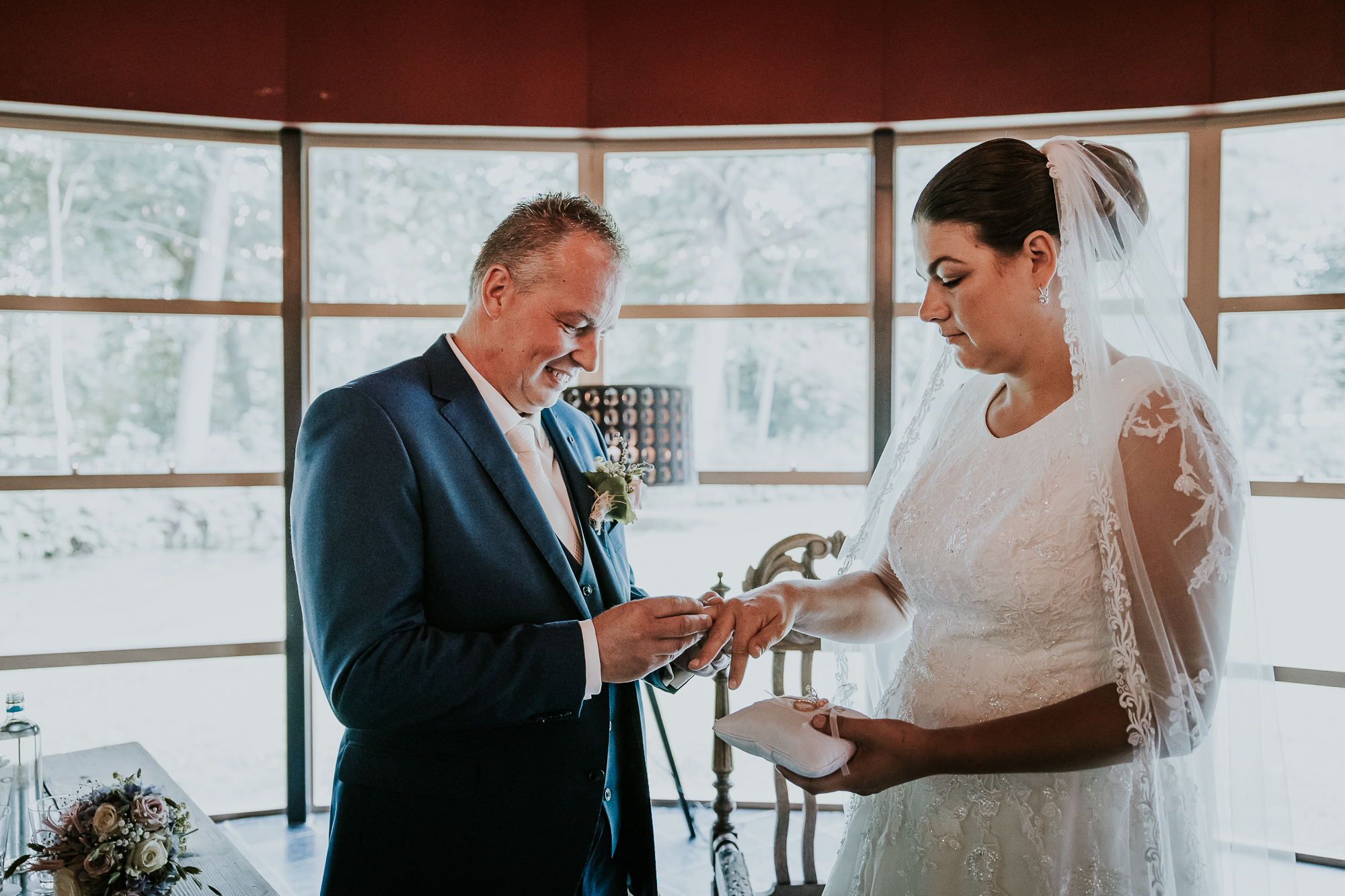 Het uitwisselen van de trouwringen. De bruidegom geeft zijn bruid de ring. Bruidsfotografie door bruidsfotograaf Nickie Fotografie uit Dokkum, Friesland.